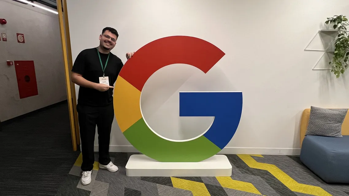 Cainã ao lado de um G gigante do Google